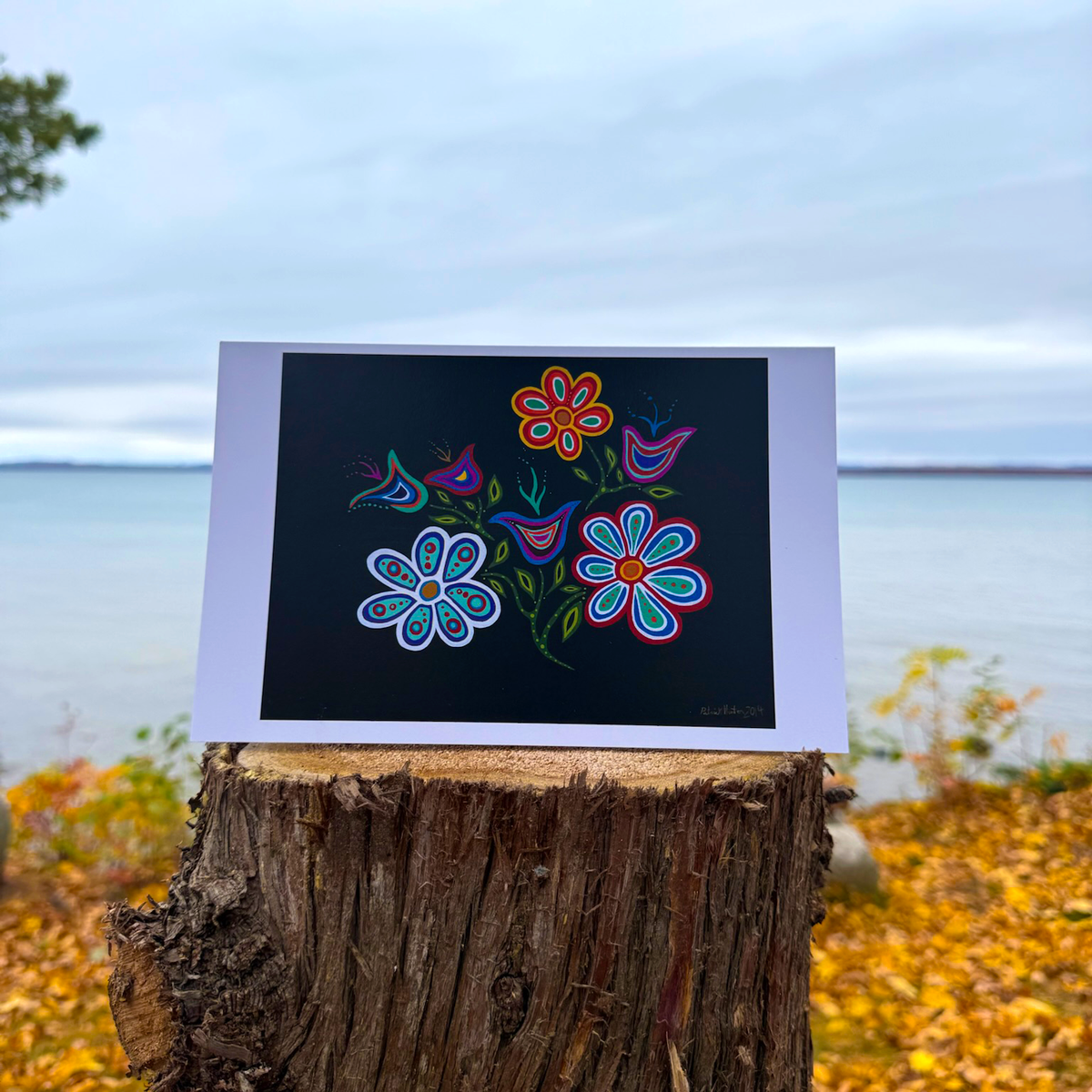 A greeting card of Patrick's woodland art style painting of vibrant flowers against a dark background.