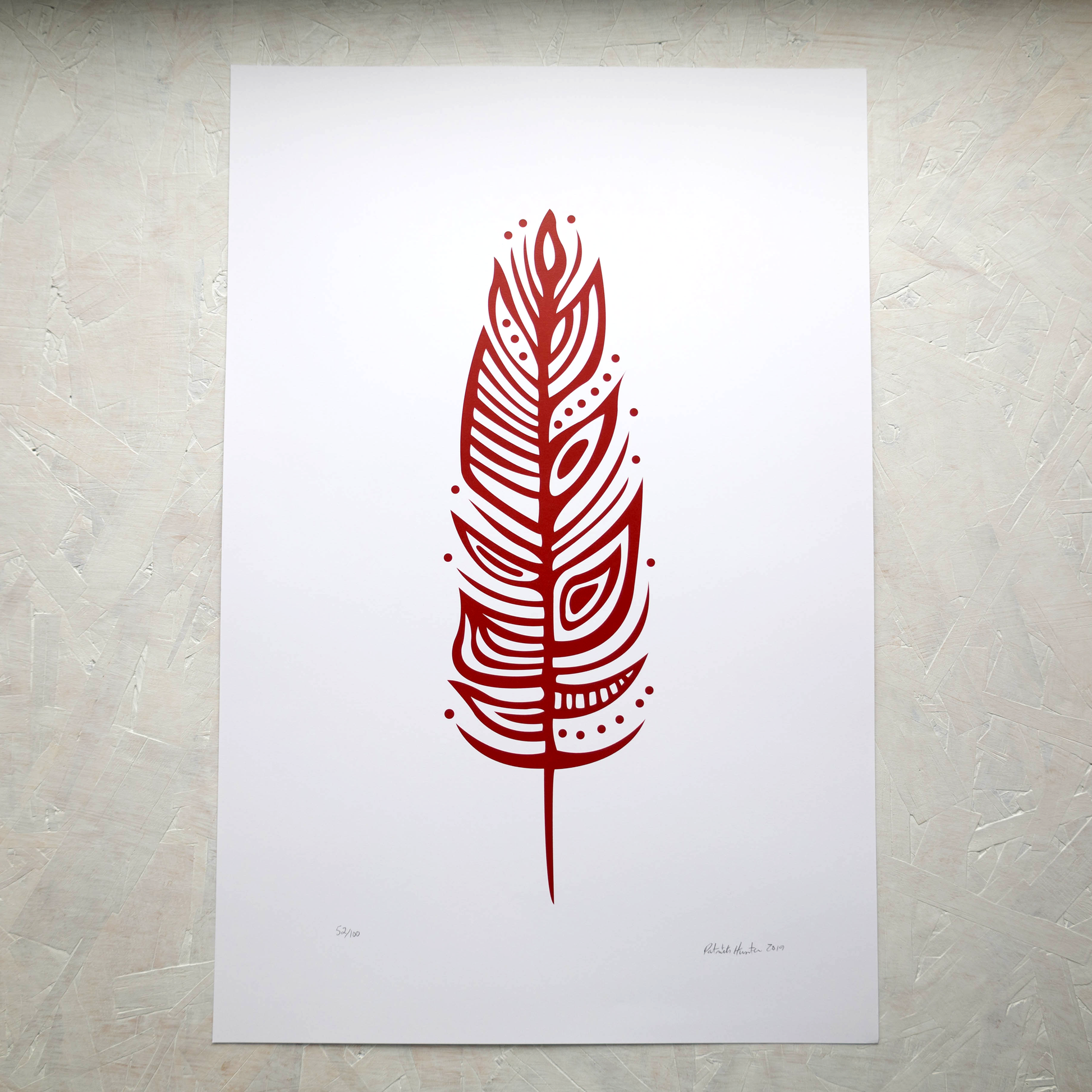 Print of Patrick Hunter's painting of an eagle feather in red on white, woodland art style.