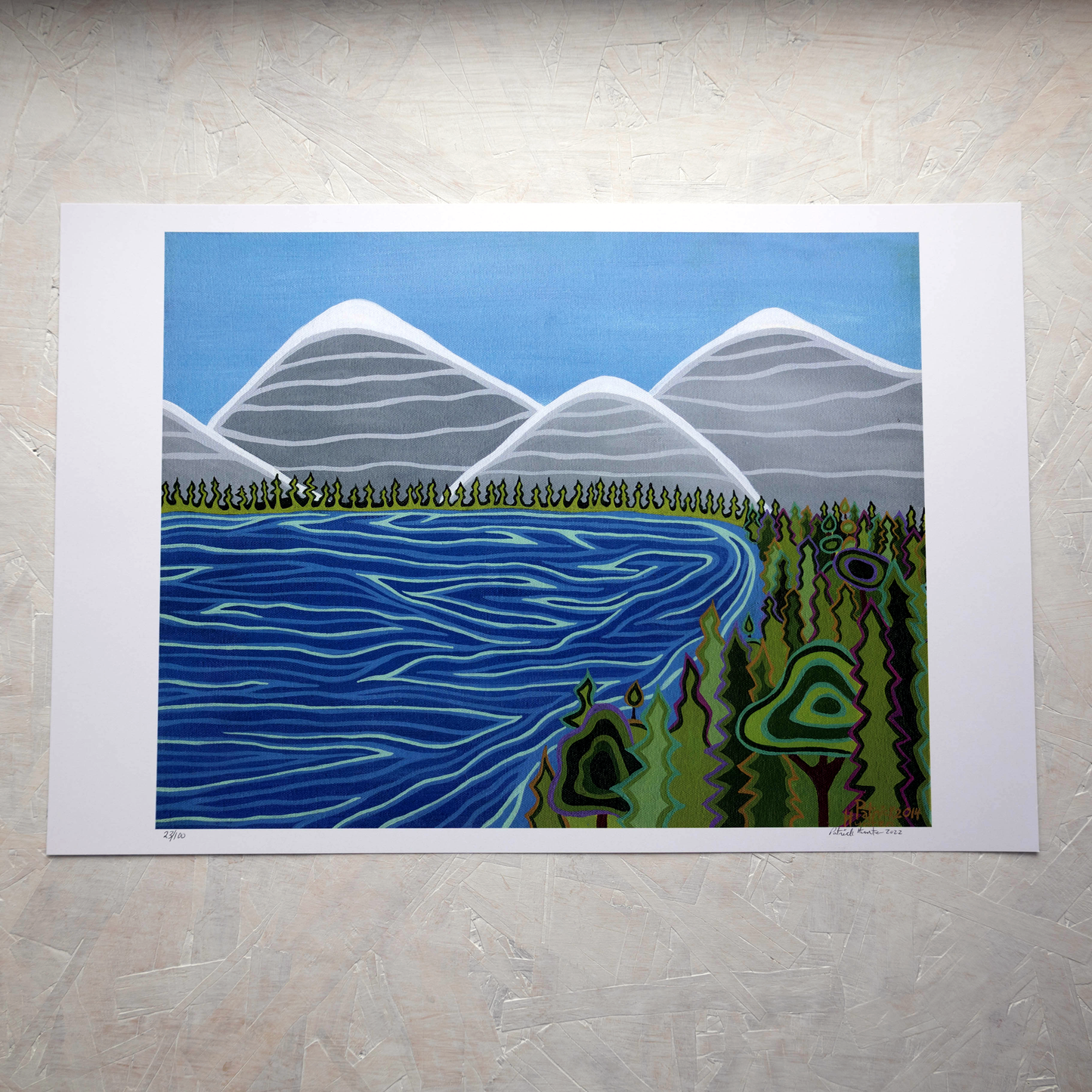 Print of Patrick Hunter's painting of a body of water with forest and mountains in the background, woodland art style.