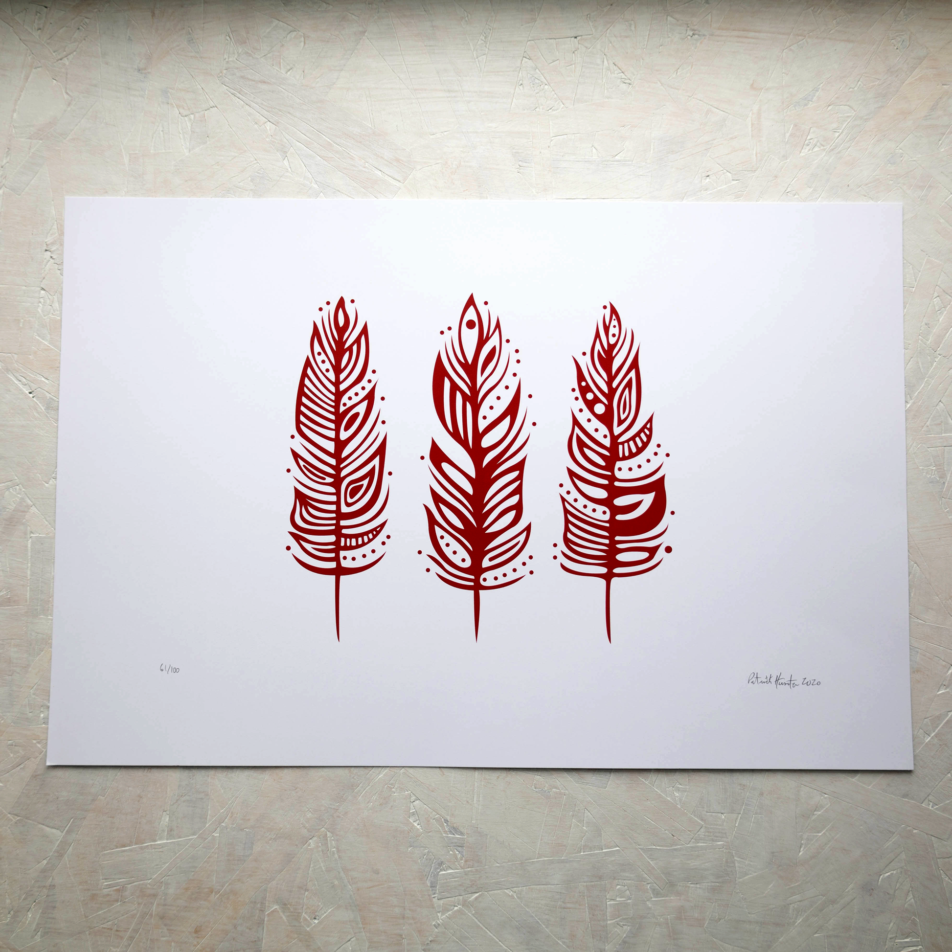 Print of Patrick Hunter's painting of three feathers, red on white, woodland art style.